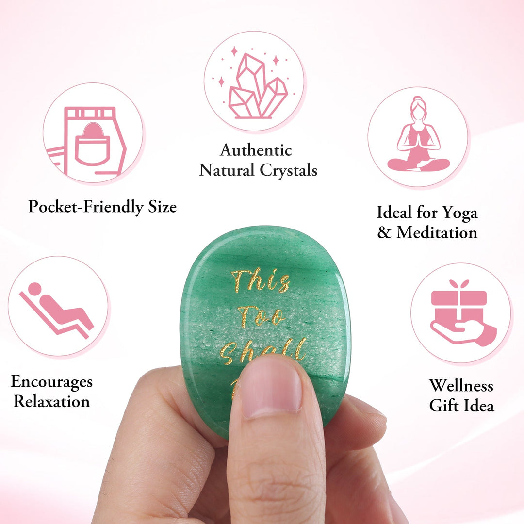Green oval crystal stone held in hand with gold “This Too Shall Pass”