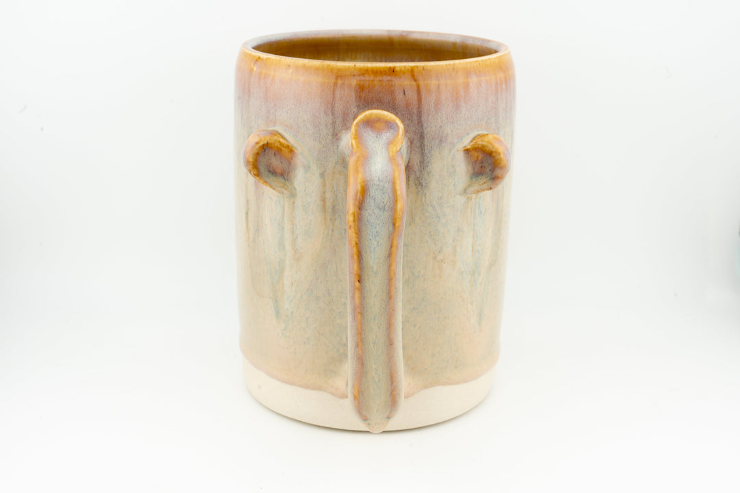 Ceramic stein mug with central drip detail, light cream body, caramel-brown rim