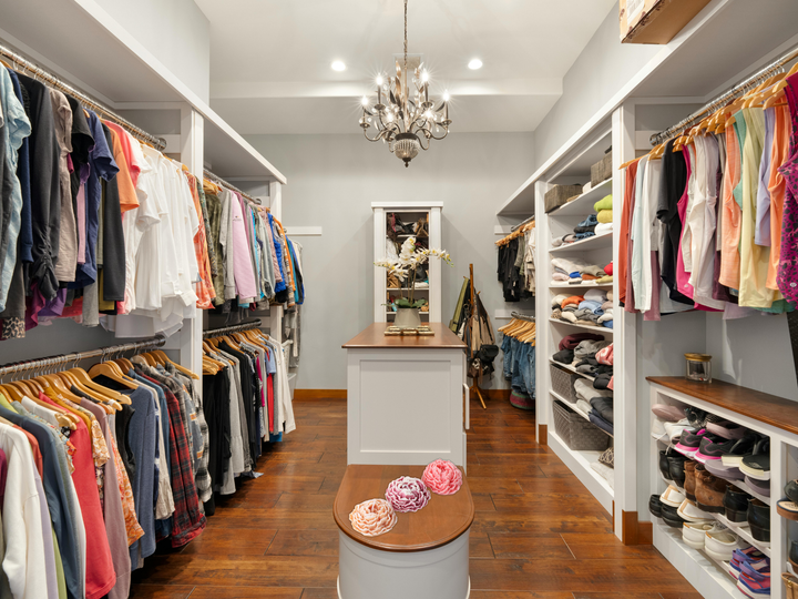 Walk-in closet with a small pink wax flower freshener on a storage surface
