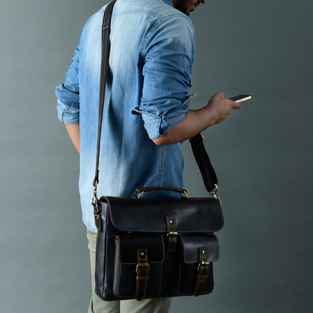 Dark blue laptop messenger bag with front flap pockets and adjustable shoulder strap