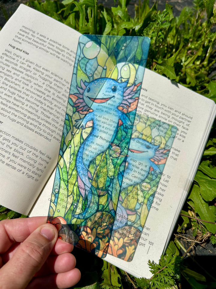Blue axolotl bookmark in an open book, colorful handmade design on the page