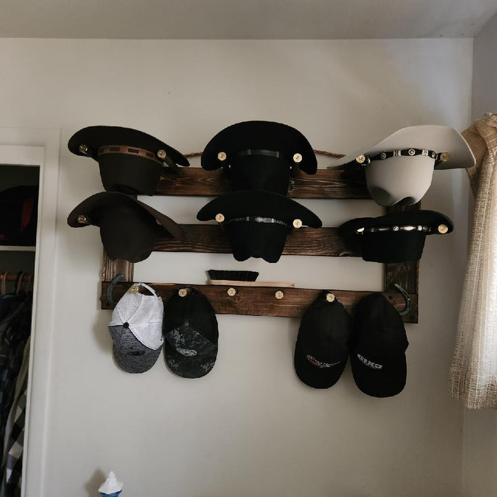 Horizontal wall-hanging hat organizer with black and light hats on three wooden bars