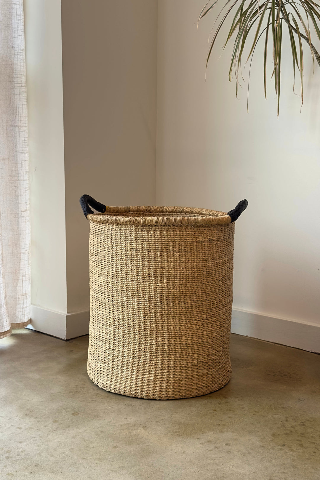 Round woven pot basket with double handles, tan weaving and black rope handles