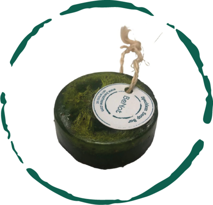 Dark green round herbal soap bar with white circular label on top