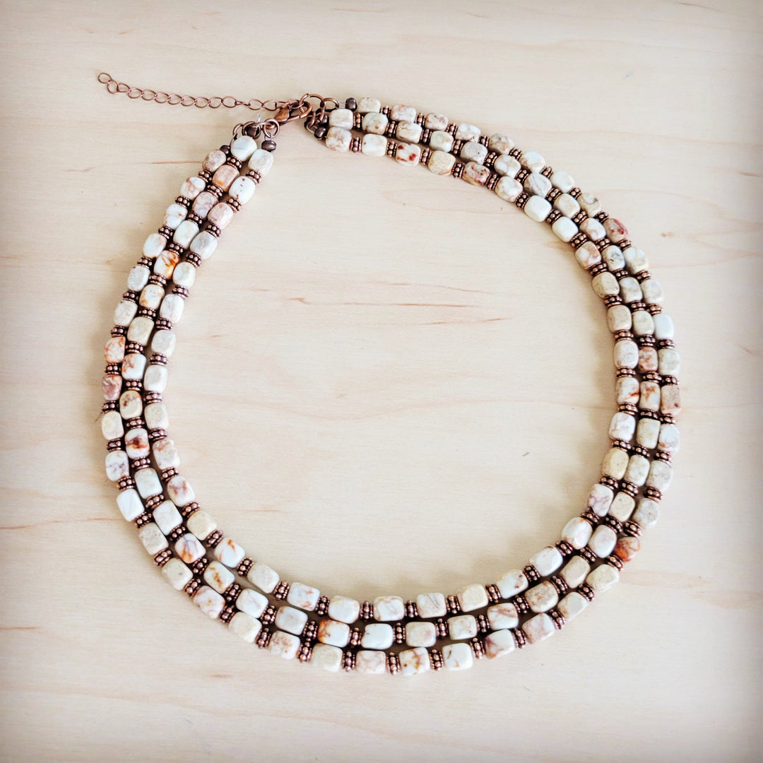 Layered triple-strand beaded necklace with white, bronze and black cube beads