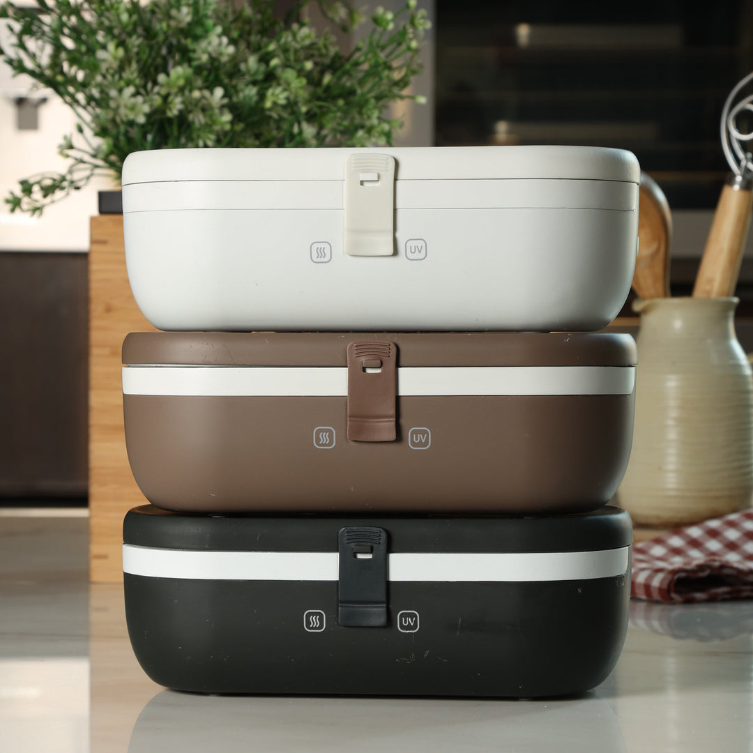 Three self-heating lunch boxes stacked in white, brown, and black colors