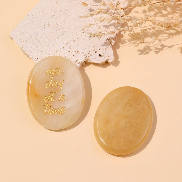 Light beige round pocket crystal stone with gold “one day at a time” text