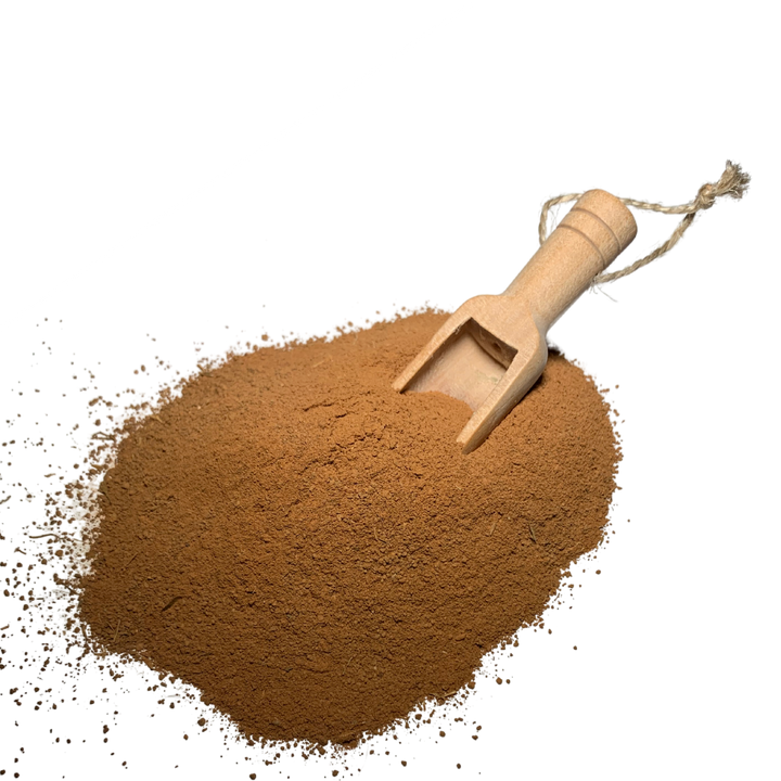 Mud and arnica mask powder in wooden scoop, loose brown clay