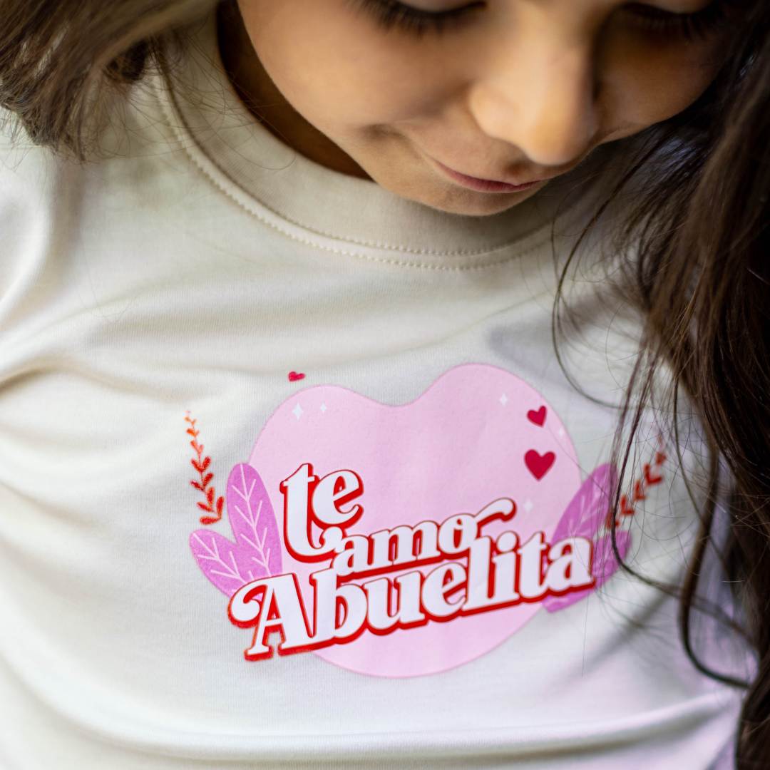Cream graphic tee with pink heart graphic and "Te amo Abuelita" text with flowers