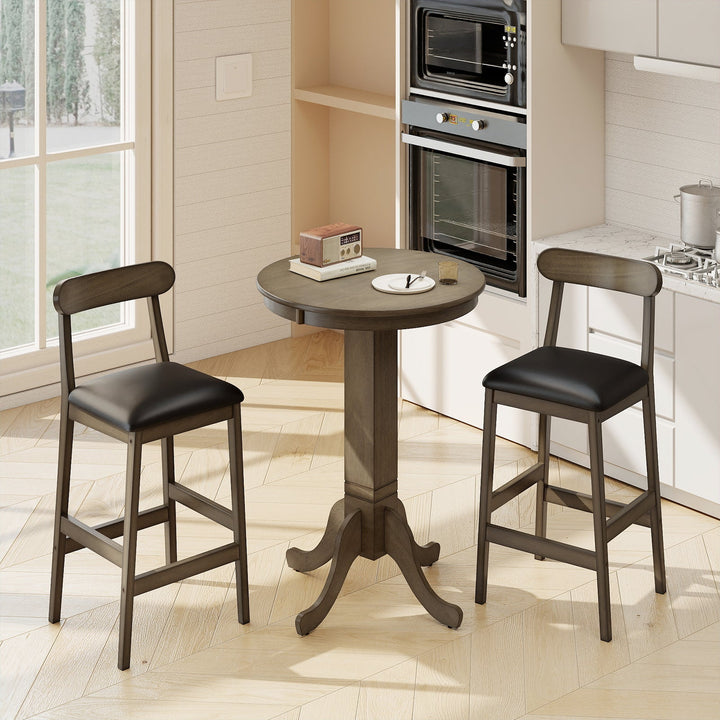 Round pub table with pedestal base and two stools by oven; dark wood and black seats