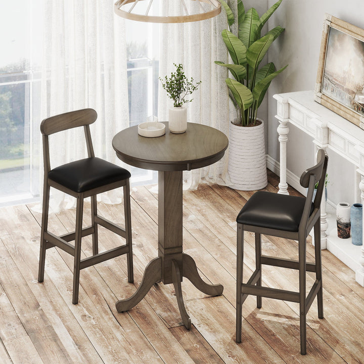 Round pub table with pedestal base plus two stools; dark wood and black seats