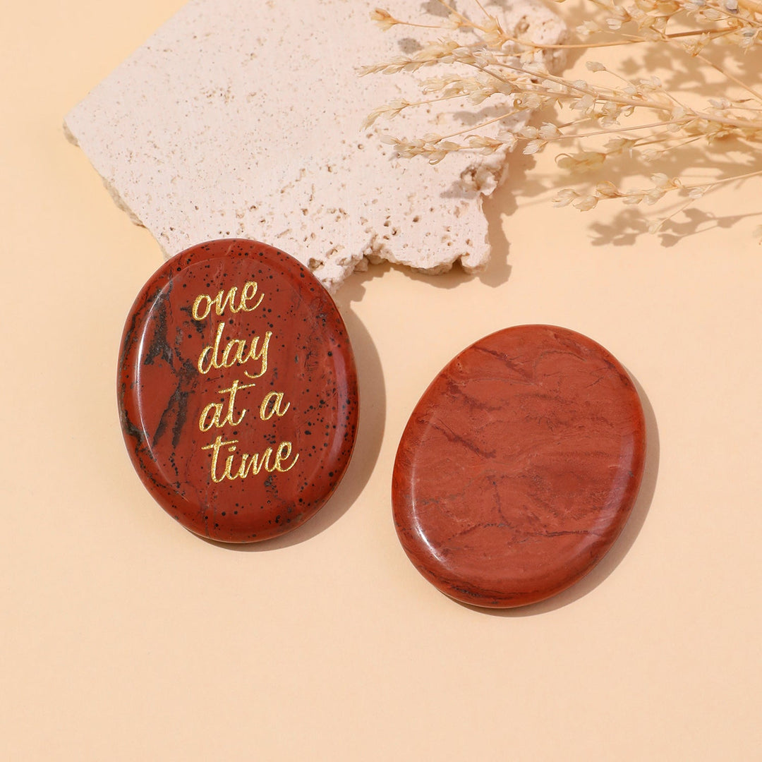 Red round pocket crystal stone with gold “one day at a time” text