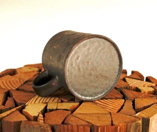 Stone-gray and bronze espresso mug, bottom view with pour opening and speckled underside