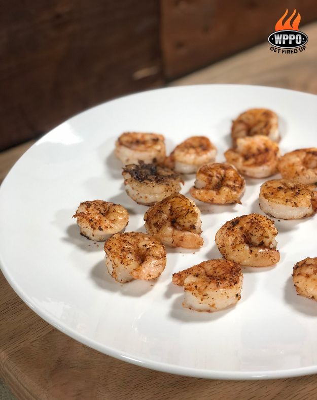 Seasoned grilled shrimp bites on a white plate