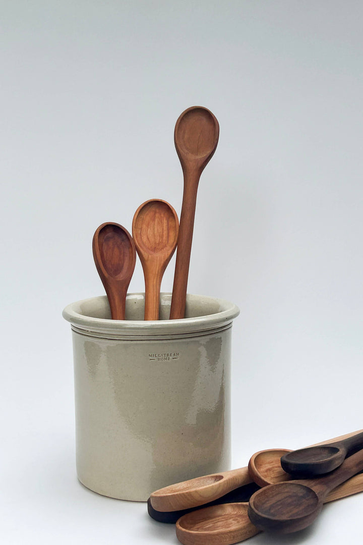 Wooden spoons in a ceramic cup, assorted oval-bowl utensils with long handles