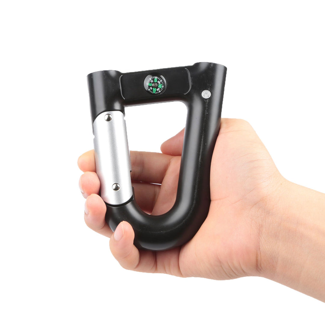 Black and silver carabiner power bank held in hand, compass dial on top
