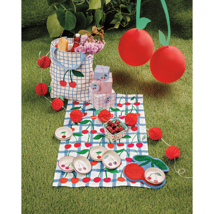 Cherry storage basket with picnic items on grass
