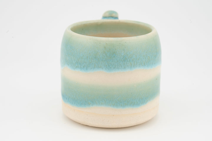 Ceramic mug with turquoise-blue glaze gradient and small top opening.