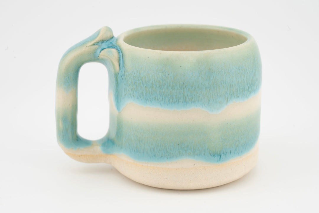 Ceramic mug with turquoise-blue glaze gradient and left-side handle.