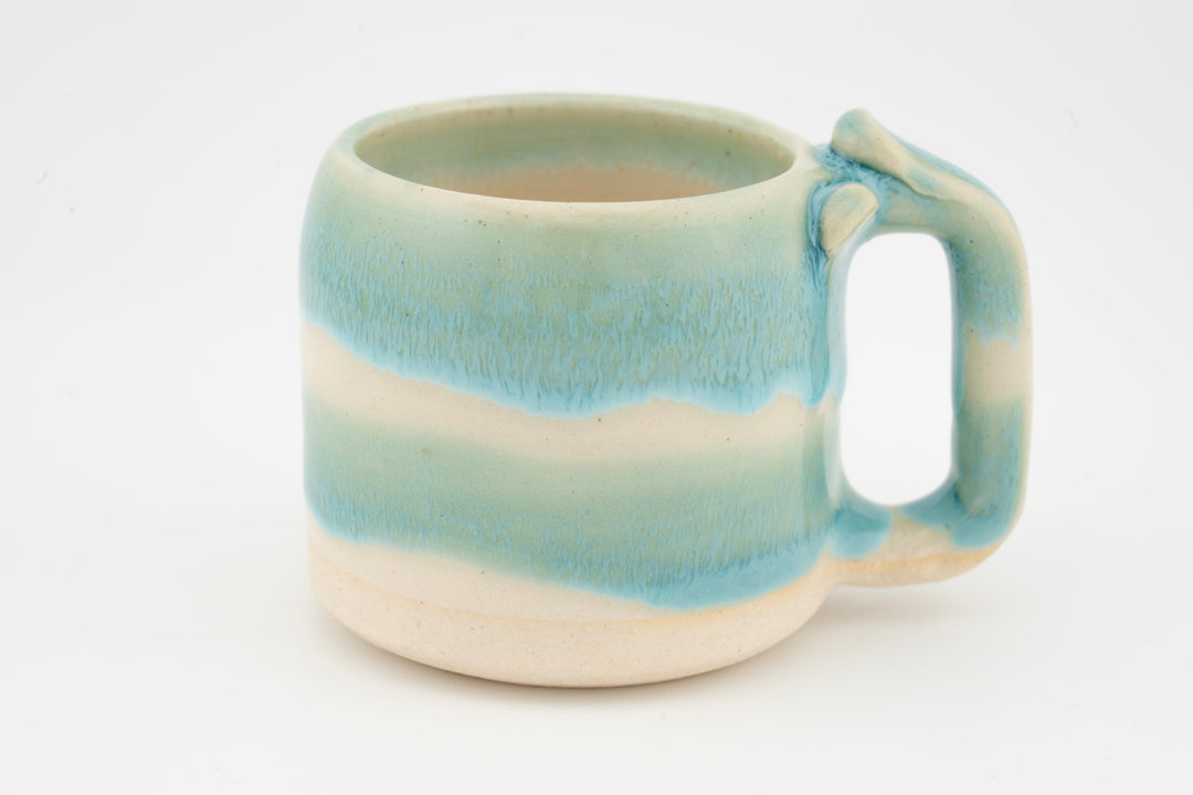 Ceramic mug with turquoise-blue glaze gradient and right-side handle.