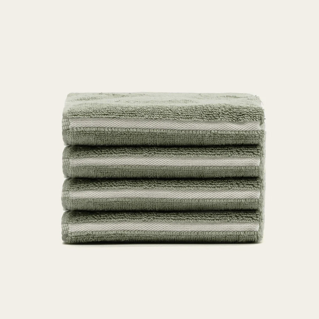 Sage green cotton towels folded stack with horizontal stripe detailing