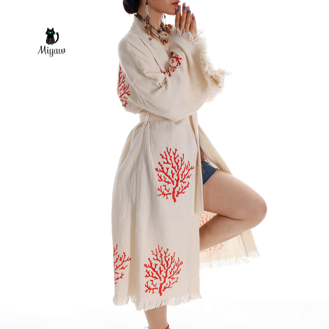 Beige kimono robe with red coral embroidery and tie belt, fringed sleeves and hem