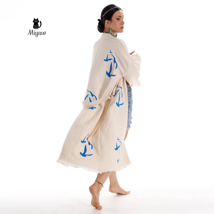 Beige seagull-print kimono robe with flowing sleeves, tied waist belt, fringe edges