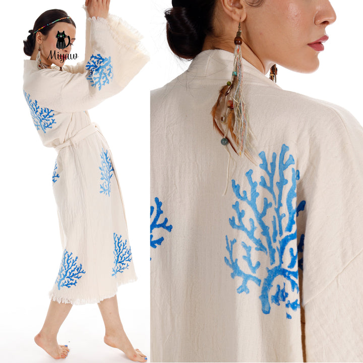 Beige kimono close-up with blue coral tree print on the back, tassel fringe at cuffs