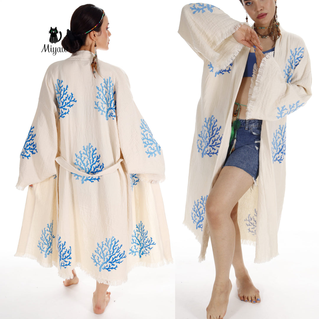 Beige organic cotton kimono over denim shorts, blue coral embroidery and long fringe edges