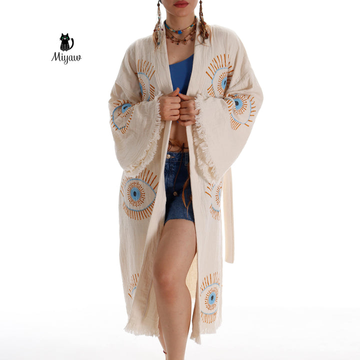 Beige cotton caftan with blue and orange evil-eye embroidery, belted waist, side slit