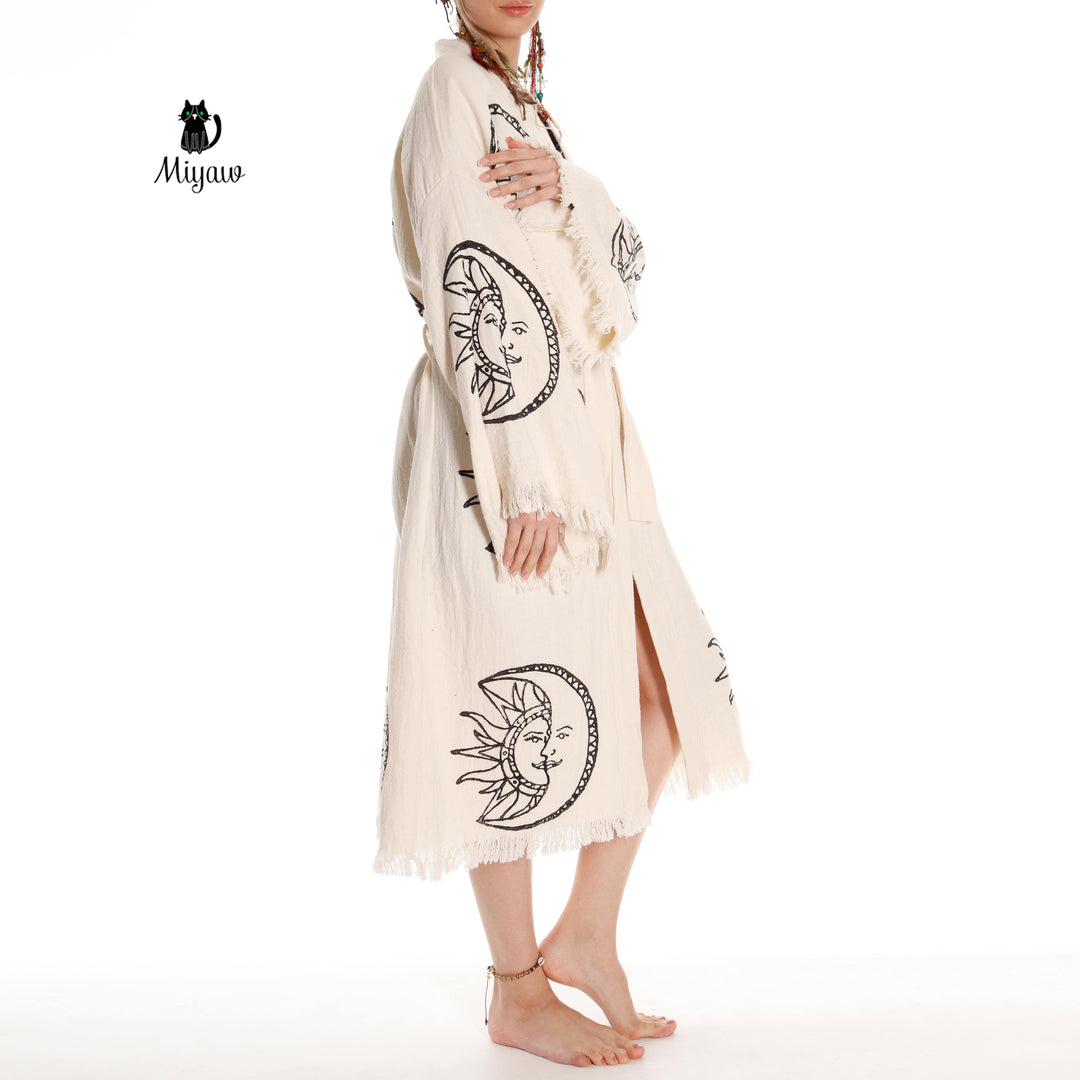 Beige organic cotton kimono robe with moon-and-sun face print, open front, fringe trim