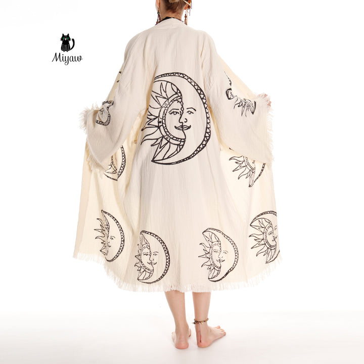 Beige organic cotton kimono robe with moon-and-sun face print, fringe cuffs, belt tie