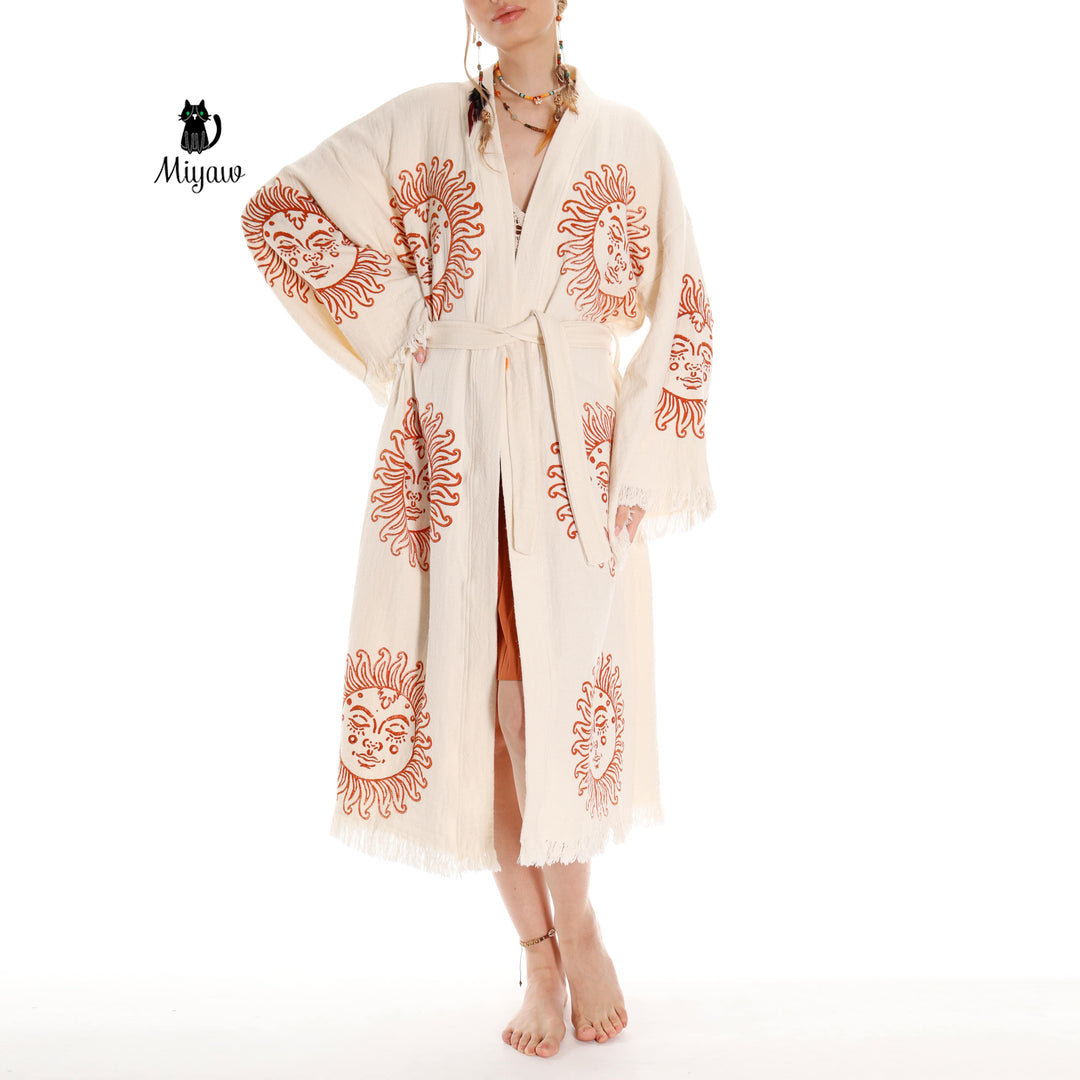 Beige cotton kimono robe with orange sun-face embroidery-style print and fringe hem