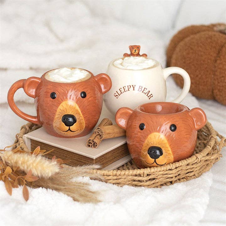 Orange bear-shaped oil burner with bear face, shown on a decorative tray with decor