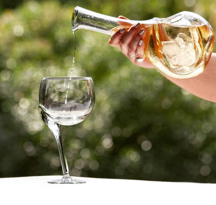 Glass wine cooler decanter pouring into a wine glass