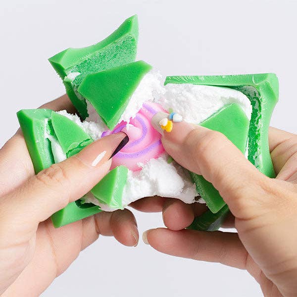 Crack-reveal wax clay squishy in green pieces with a small character figure