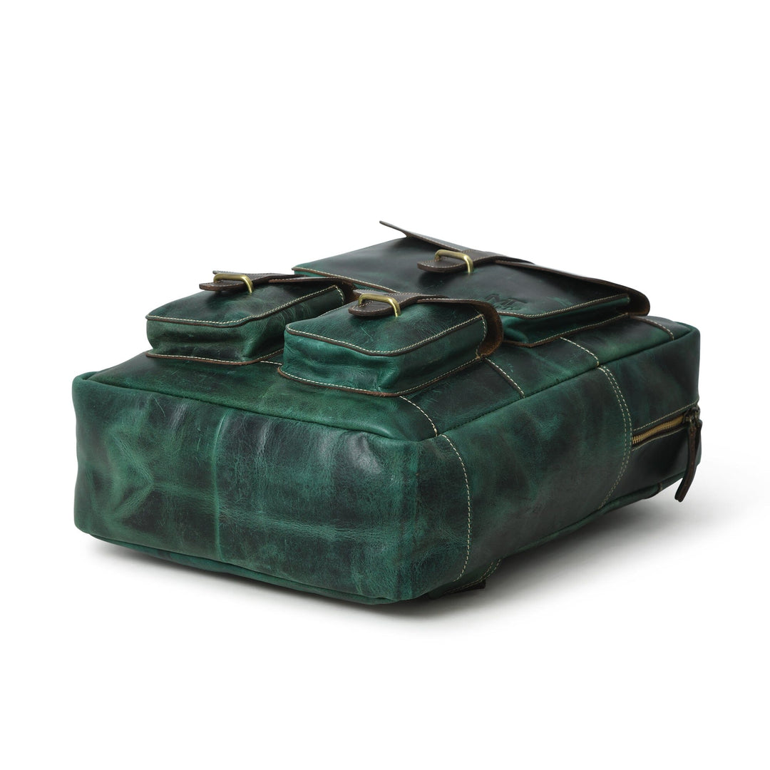 Green leather backpack with flap top and buckled straps; side view.