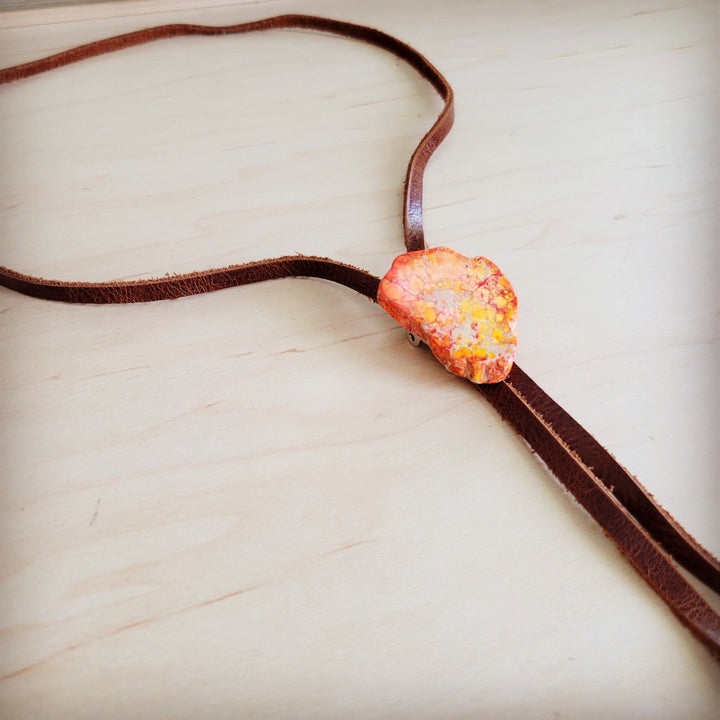 Orange heart-shaped Regalite slab pendant on brown leather lariat necklace