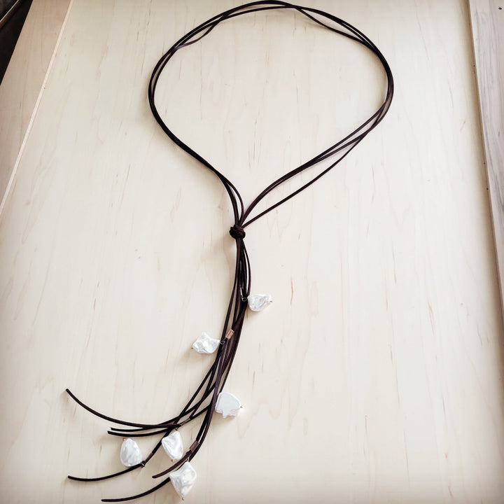 Dark brown leather cord necklace with knotted center and white pearl fringe