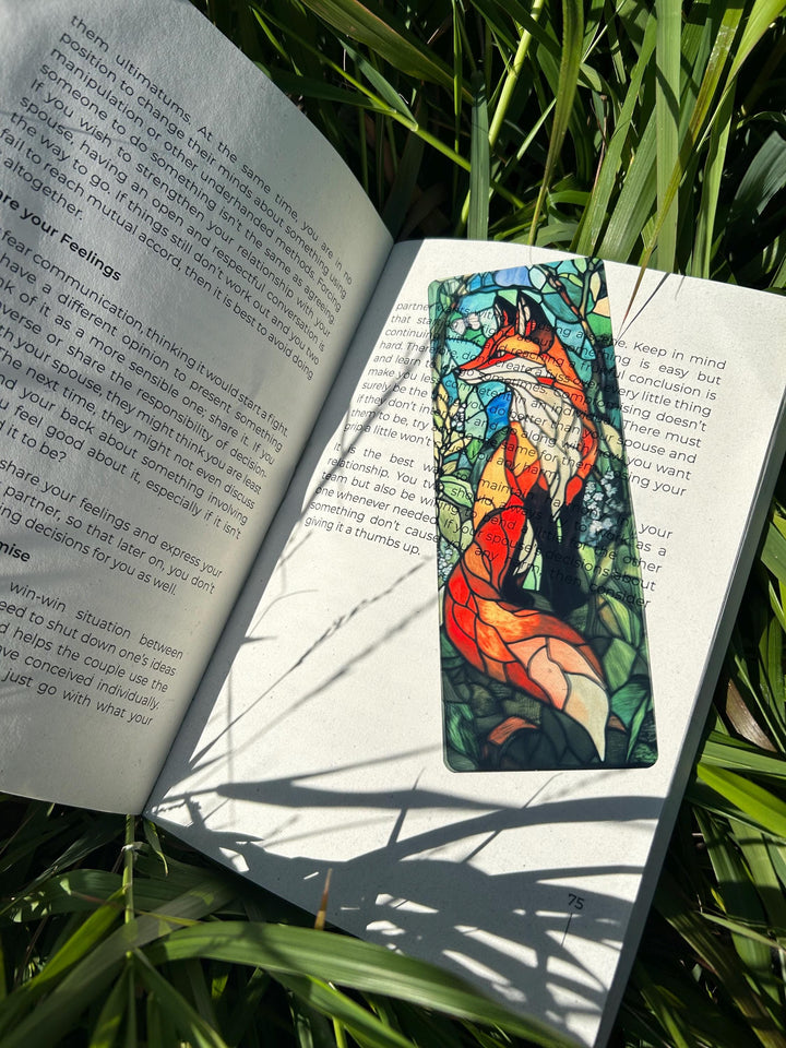 Stained-glass fox bookmark with red-orange fox and blue trees design on open pages
