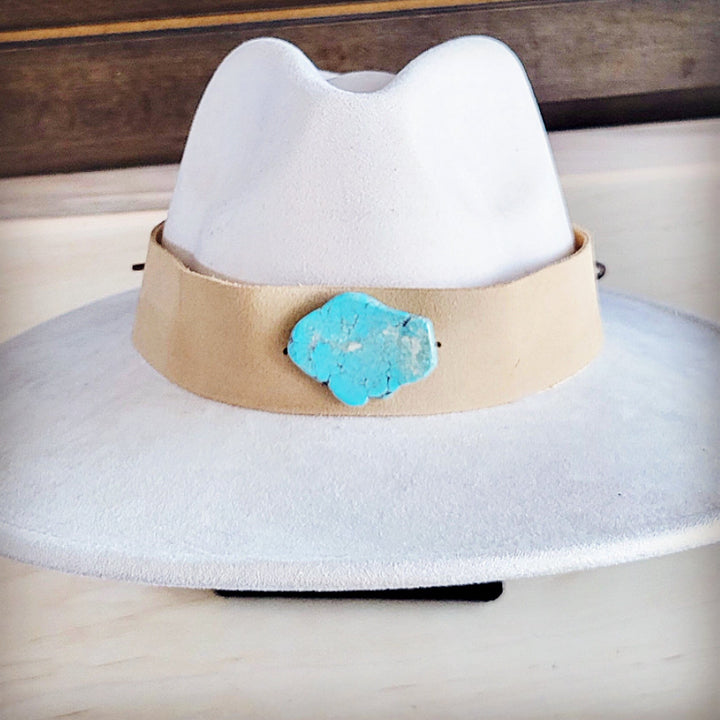 White wide-brim suede hat with tan band and turquoise concho centerpiece