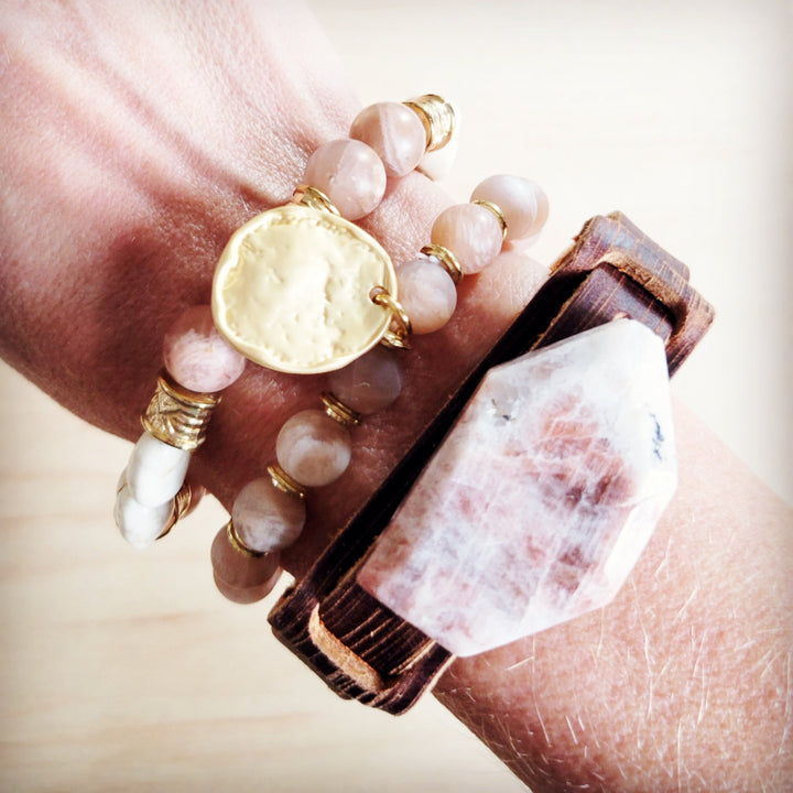 Brown leather crystal cuff bracelet on wrist with pink-white stone front