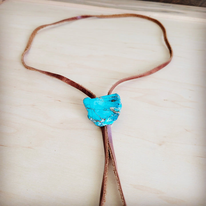 Brown leather lariat necklace featuring a large blue stone slab pendant at center