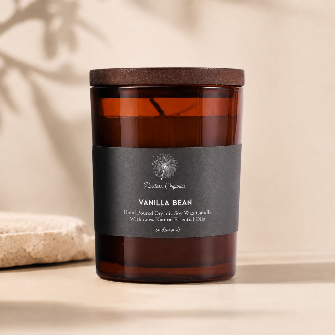 Amber jar candle with dark lid and black label, lit flame in the center.
