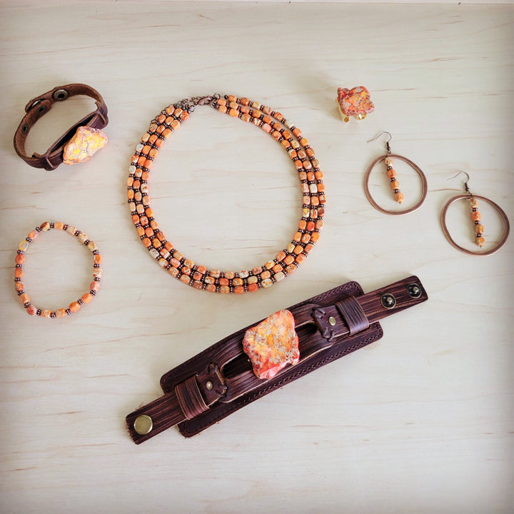 Orange beaded stretch bracelet with large heart-shaped centerpiece and dark spacers