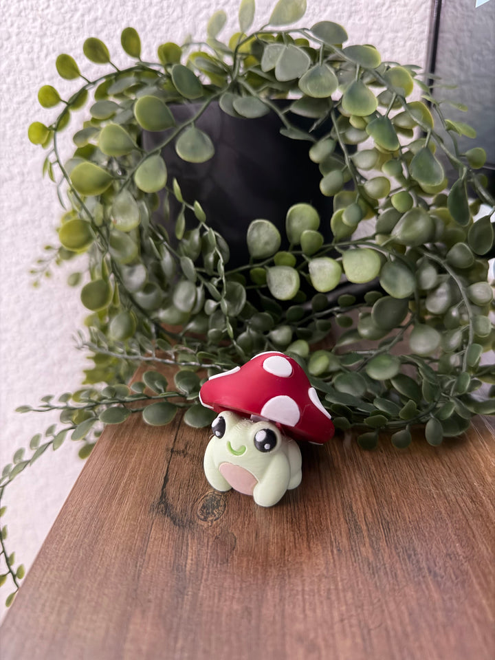 Frog toy with red mushroom cap, white spots and green face details