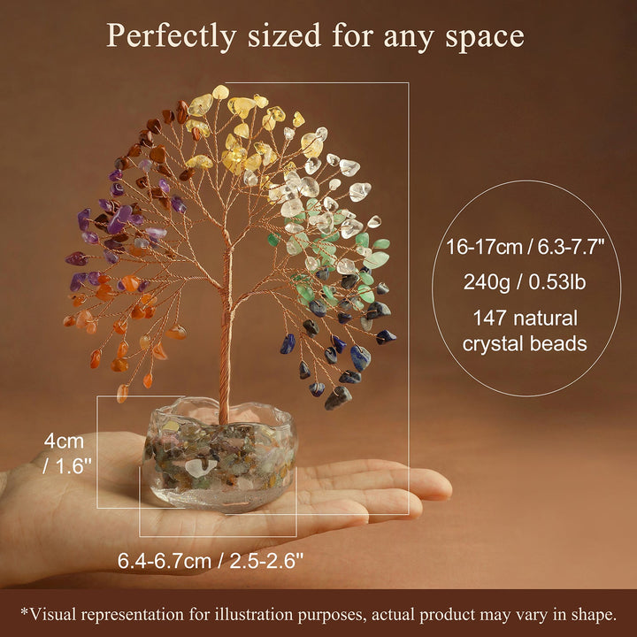 Multicolor gemstone crystal tree on stone base held in a hand