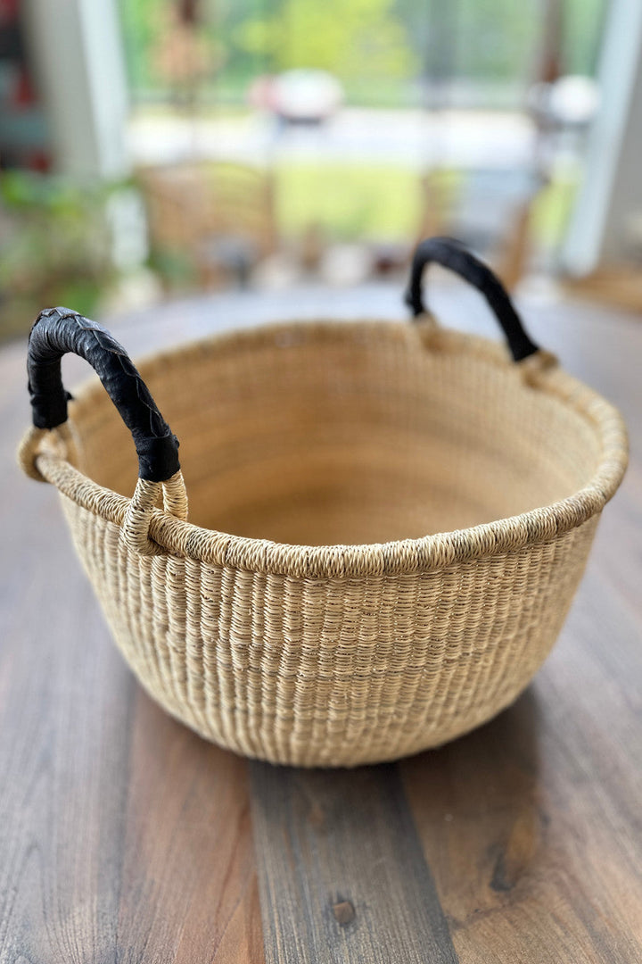 Natural rope basket with curved rim and two black carry handles
