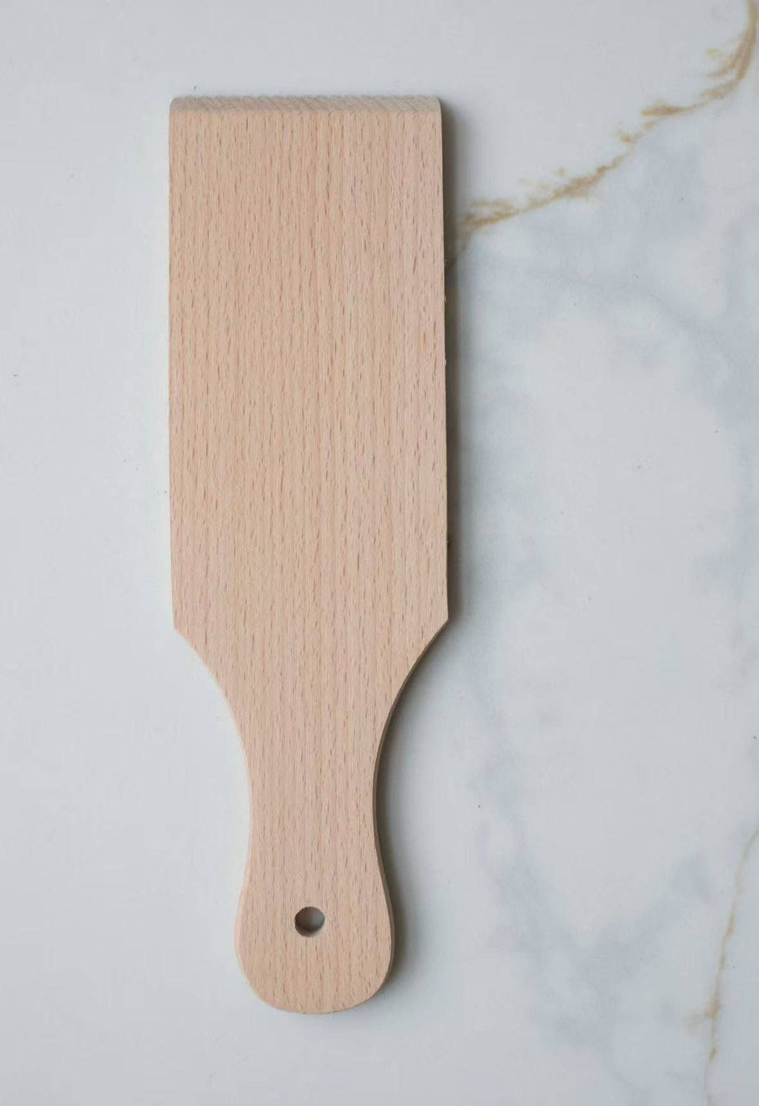 Wooden gnocchi board with smooth rectangular surface and curved handle, black dot