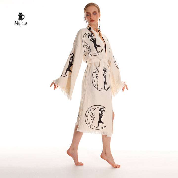 Beige cotton kimono robe front with black yoga-girl and moon prints, tassel trim